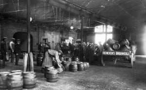 Inside view of old Heineken brewery with people moving barrels of beer